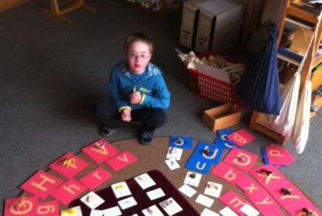 Junge vor einem Buchstabenkreis